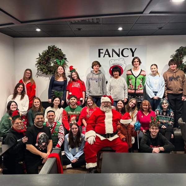 Fancy Bagels staff and Santa Claus pose for a festive Christmas group photo.